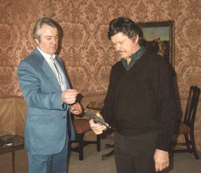 Wildey J. Moore shows the Survivor pistol to Charles Bronson.